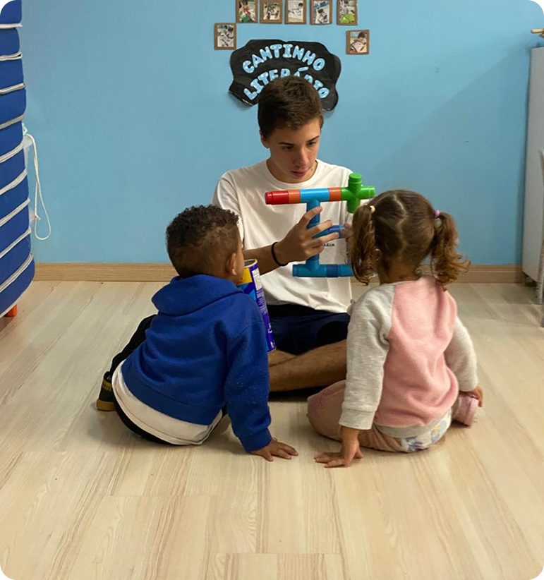 Aluno interagindo com crianças em atividade pastoral